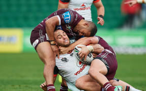 Warriors Simon Mannering is tackled by the Sea Eagles