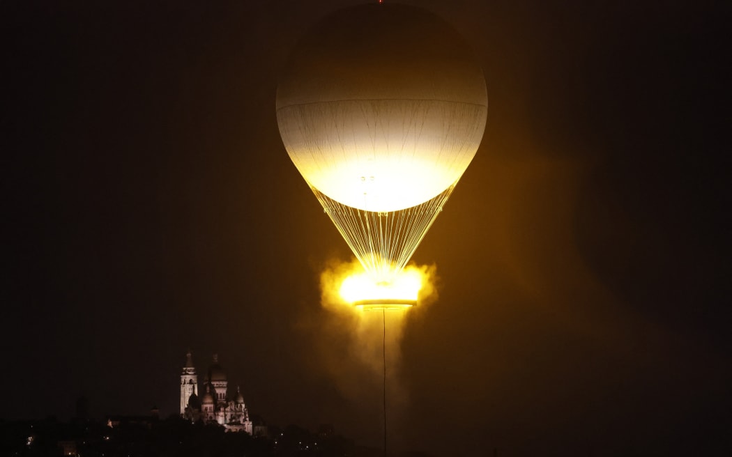 Paris 2024 Olympics - Opening Ceremony - Paris, France - July 26, 2024. A general view shows a balloon holding the Olympic cauldron after it was lit during the opening ceremony. (Photo by Peter Cziborra / POOL / AFP)