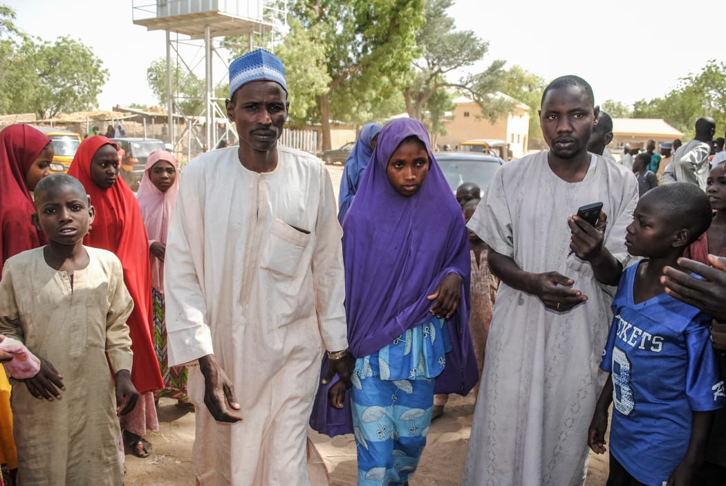 A girl released by Boko Haram walks with her father in Dapchi.