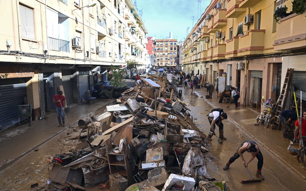 Debris are piled up along a street on November 1, 2024, following the devastating effects of flooding on the town of Paiporta, in the region of Valencia, eastern Spain. - The death toll from Spain's worst floods in a generation has climbed to 205, rescuers said today, with the number expected to rise as more people are believed missing. The agency coordinating emergency services in the eastern Valencia region said 202 people had been confirmed dead there, with officials in Castilla-La Mancha and Andalusia previously announcing a combined three deaths in their regions. (Photo by JOSE JORDAN / AFP)