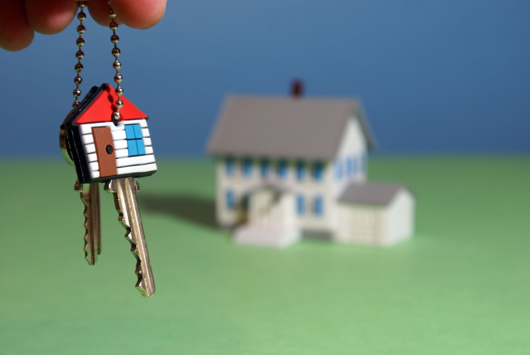 An illustration showing a hand holding keys to a new home.