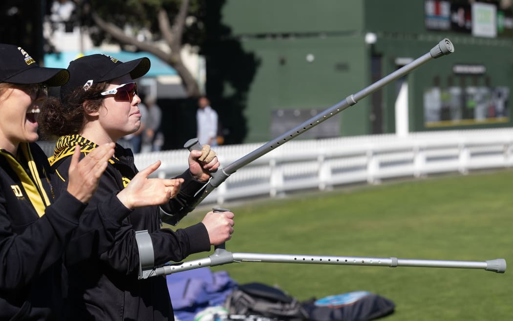 Injured Blaze player Georgia Plimmer waves her crutches at the Basin Reserve, 2024.