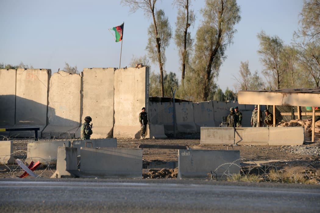 Afghan security personel stand guard near the airport complex in Kandahar on December 9, 2015.