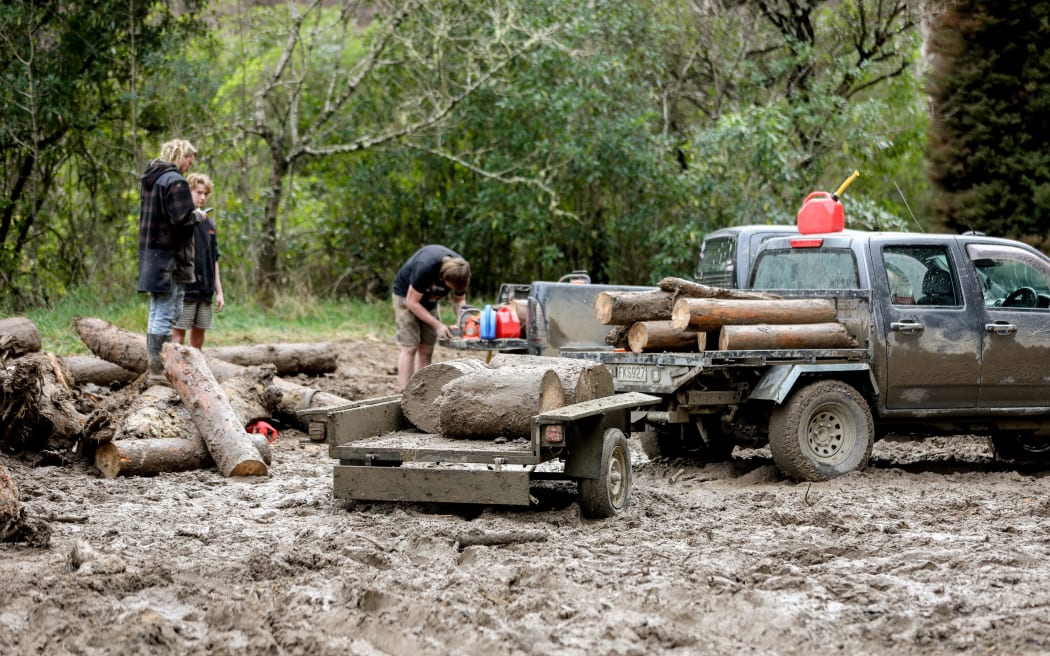 Men cutting up and clearing fallen trees in Motueka Valley.