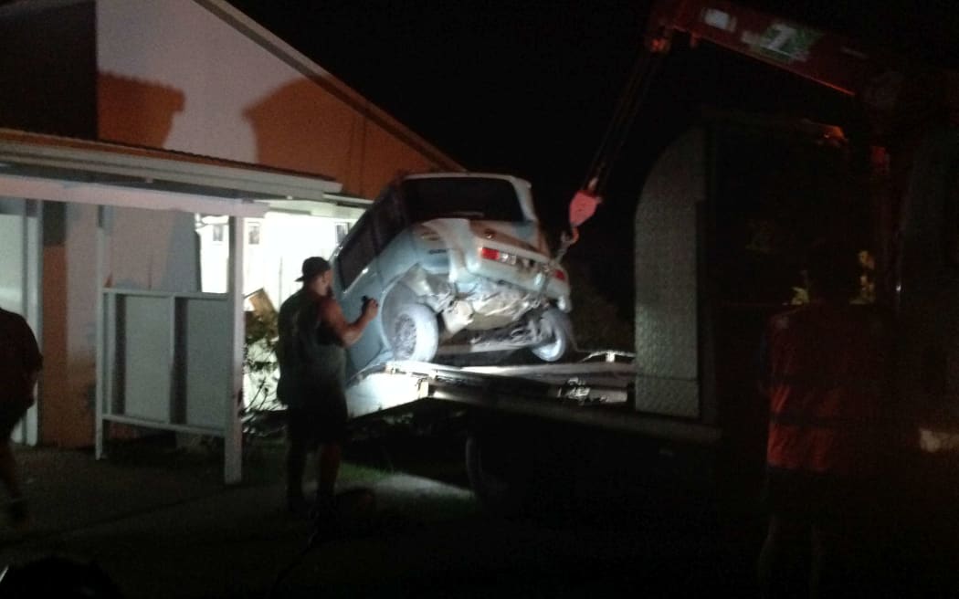 A car is removed from the western wall of the Cook Islands parliament.