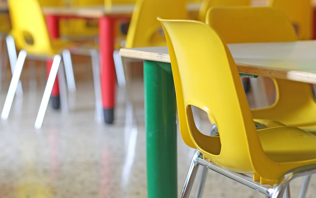 A file photo shows bright yellow chairs in a kindergarten or pre-school.