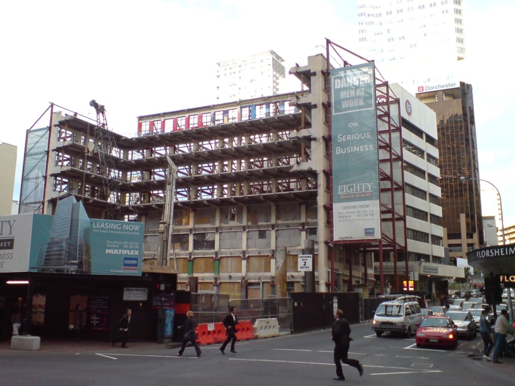 The Jean Batten building in Auckland City, New Zealand, after its almost complete demolition. Small sections were kept as part of the new skyscraper building seen on the advertisement billboard in front.