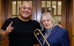 Roger Fox and King Kapisi standing in front of a door.