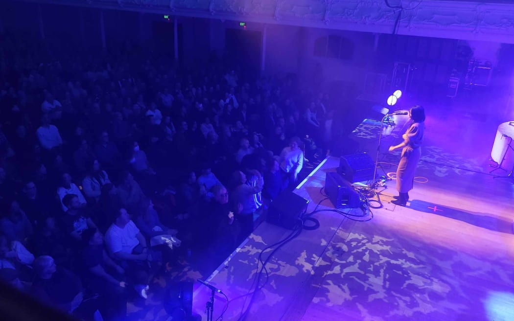 A small group of women dancing in front of Bic Runga.