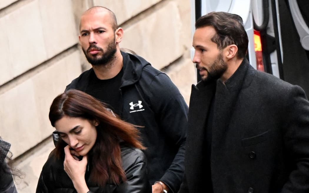 British-US former professional kickboxer and controversial influencer Andrew Tate (C), his brother Tristan Tate (R) arrive handcuffed and escorted by police at a courthouse in Bucharest on January 10, 2023 for a court hearing on their appeal against pre-trial detention for alleged human trafficking, rape and forming a criminal group. (Photo by Daniel MIHAILESCU / AFP)