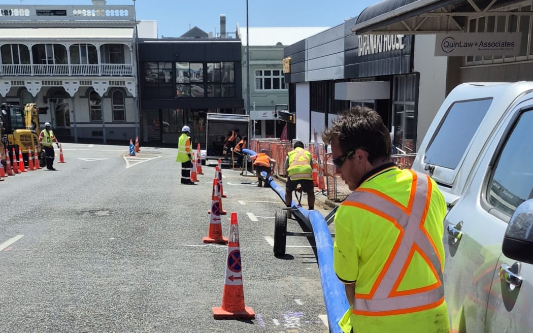 Fulton Hogan workers move the new pipe into place in Robe Street.