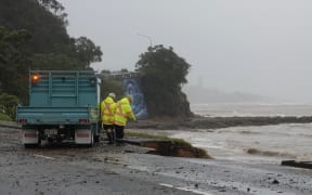 Workers inspect damage to SH11/Marsden Road in Paihia on Thursday.