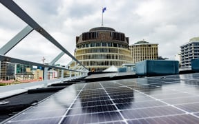 On the roof of Parliament House, the Beehive is reflected in one of the many ranks of new solar panels.