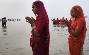 A Hindu devotee prays after taking a holy dip in the Bay of Bengal during the Gangasagar Mela, at Sagar Island, some 150 kilometres south of Kolkata on January 14, 2021.