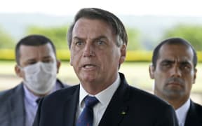 President Jair Bolsonaro (centre) maintains that Brazilians must keep working while taking precautions not to catch Covid-19.