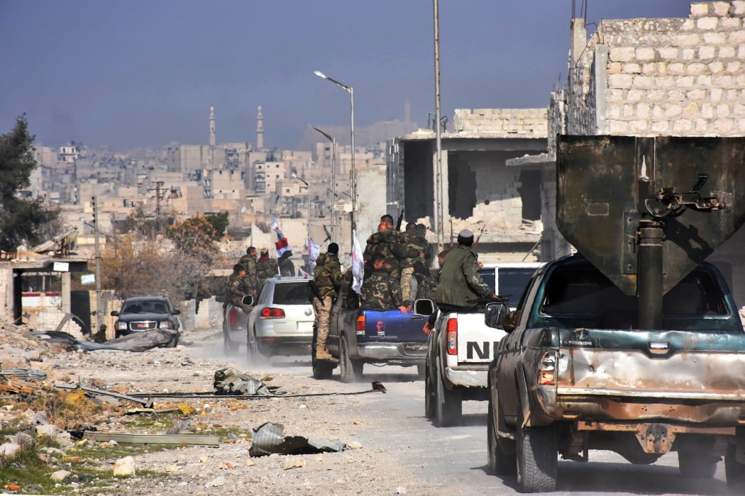 Syrian pro-government forces patrol Aleppo's Sheikh Saeed district, on 12 December, 2016, after troops retook the area from rebel fighters.