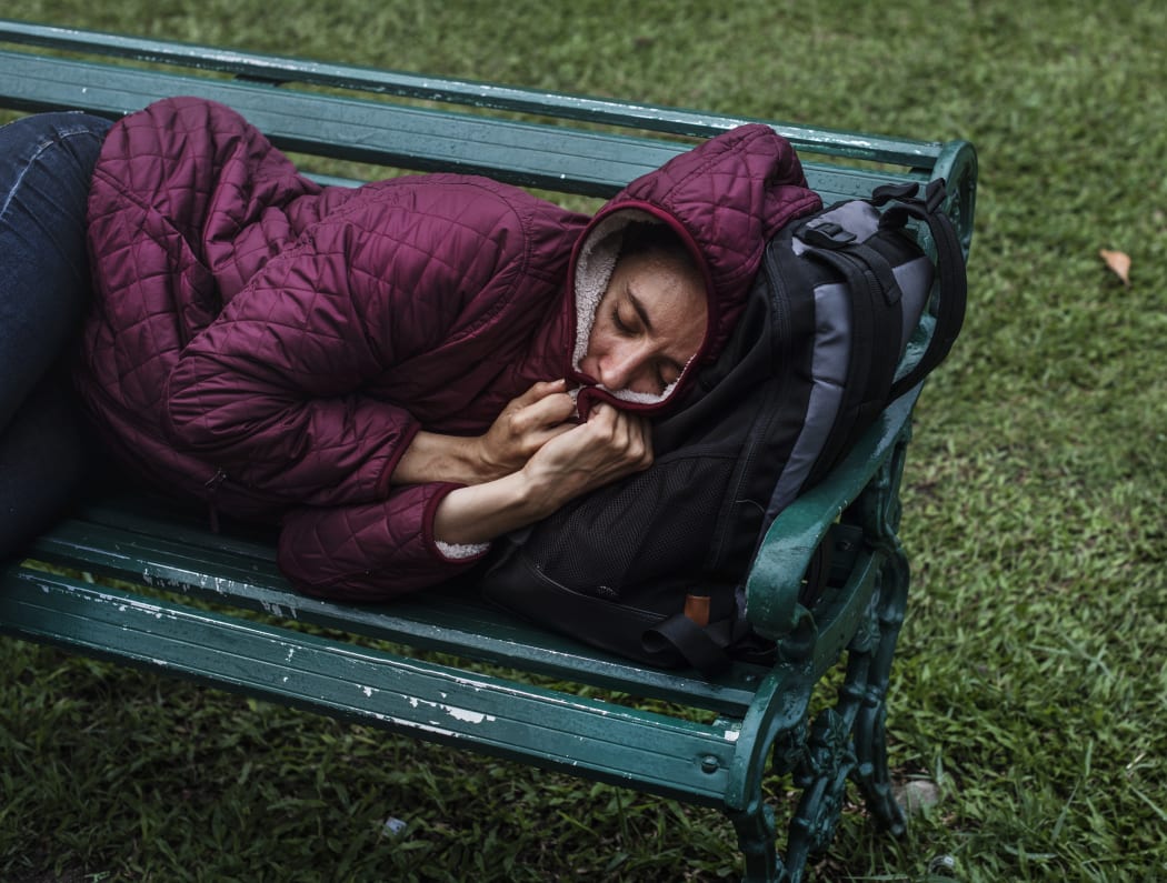 File image: A homeless woman sleeps on a bench