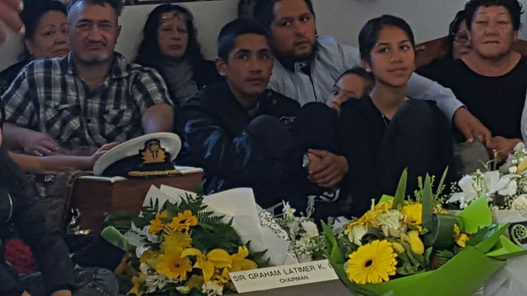 Whānau of Sir Graham Latimer surround his coffin listening to eulogies at his funeral.