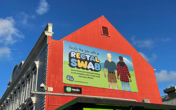 A Finish the Job with a Rectal Swab billboard on the side of a building as part of Sex Outside the City campaign.