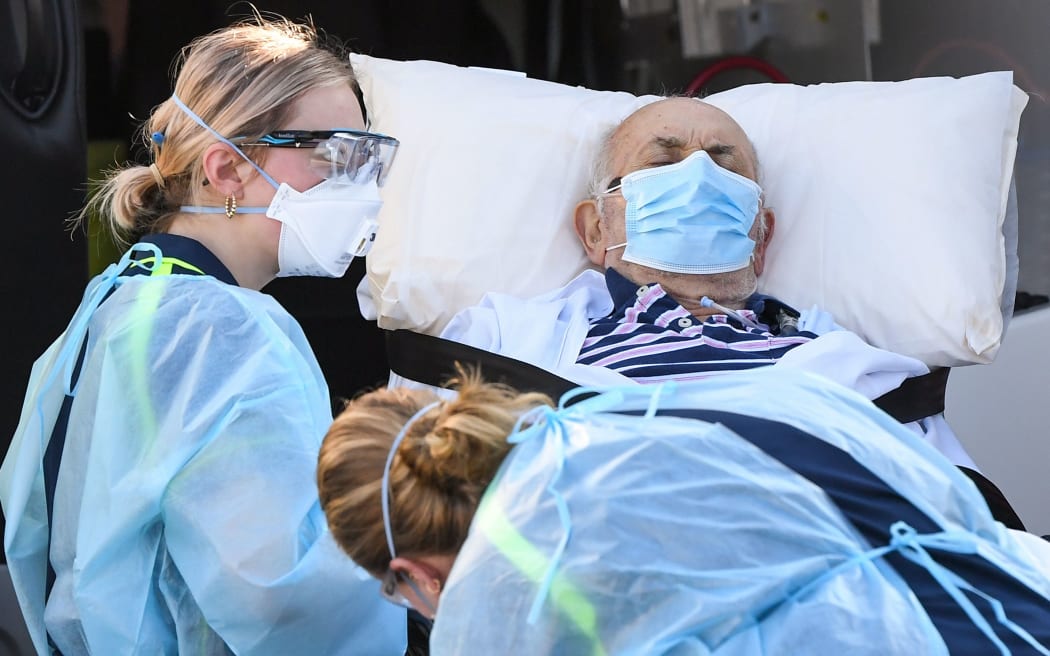 Ambulance officers transport a resident from the Epping Gardens aged care facility in the Melbourne suburb of Epping on July 29, 2020, as the city battles fresh outbreaks of the COVID-19 coronavirus.