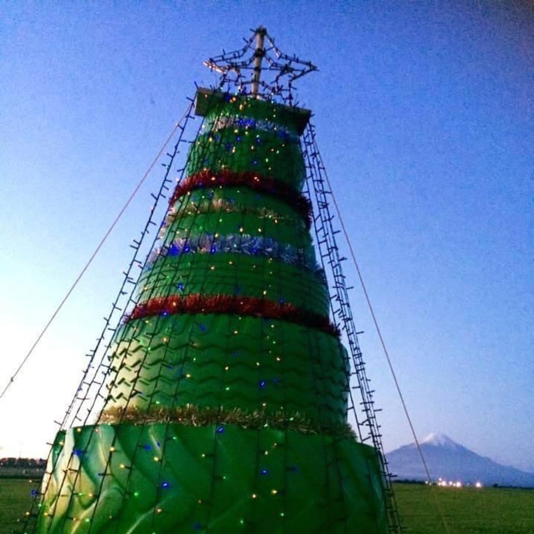 Tyres stacked like a christmas tree in front of Mount Taranaki.