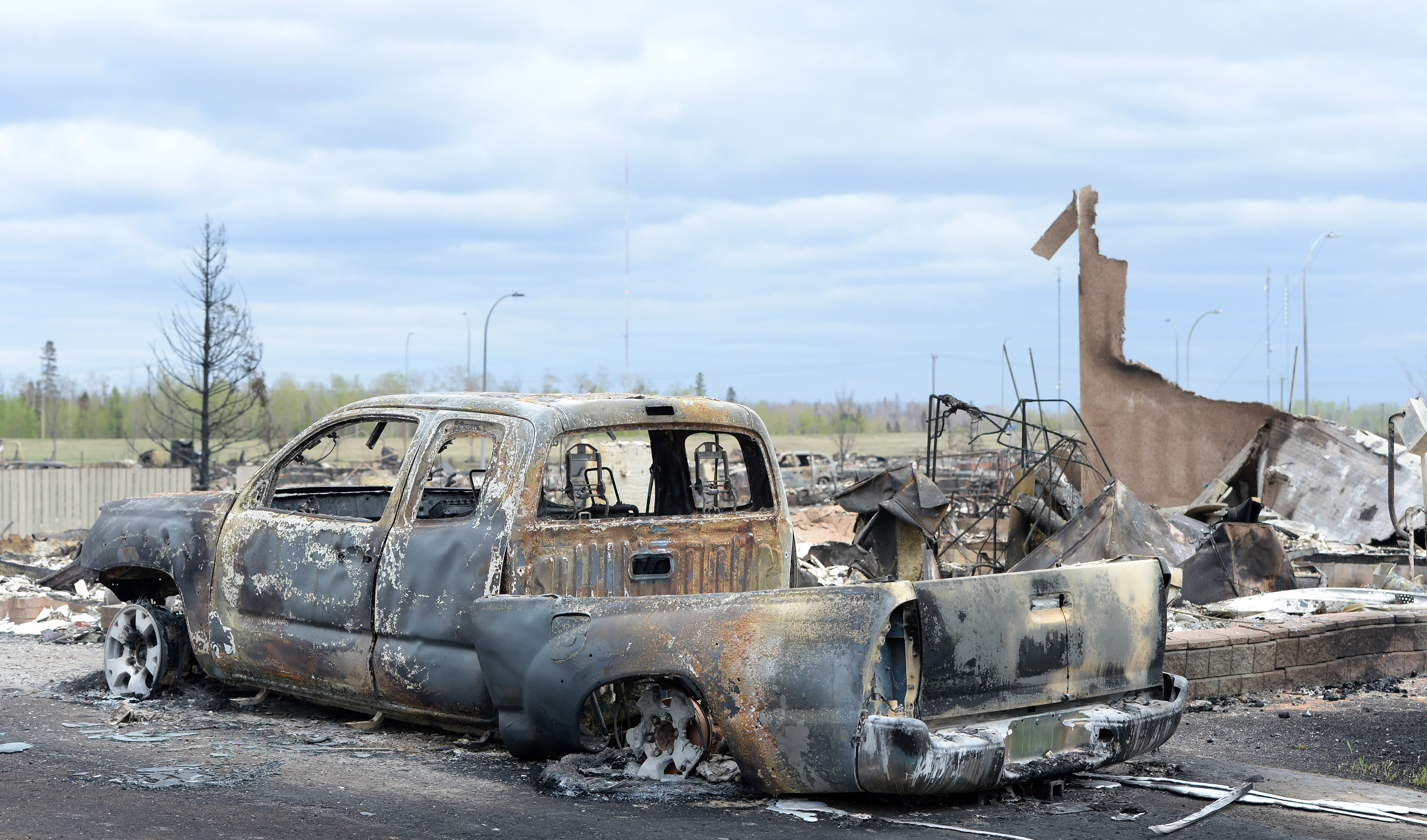A burned out truck and the remains of a house in the Beacon Hill neighbourhood of Fort McMurray.