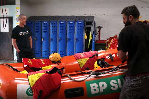 Illinois Cooney and other lifeguards at Piha Surf Lifesaving Club in the gear shed.