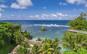 Tropical Samoan resort with clear blue waters, white sand and coconut palms