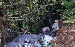 Trash dumped illegally down a hillside on Longbush Rd in January 2026.