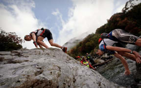 Competitors climb over large boulders in the Mingha Deception Route on the way to Goat Pass during the first day of the Coast to Coast in 2010.