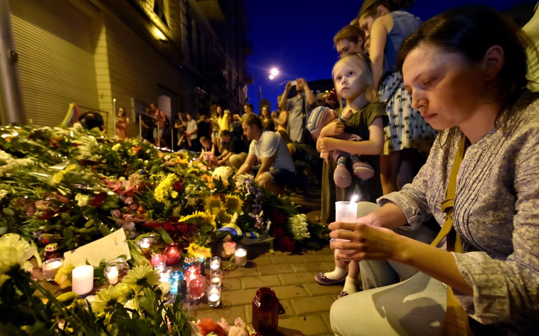 A woman lights a candle in front of the Embassy of the Netherlands in Kiev, Ukraine.