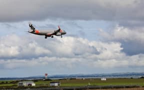 Jetstar plane flies in to Auckland Airport.