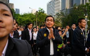 Thailand's Prime Minister Prayut Chan-O-Cha (C) greets people at Lumphini Park in Bangkok on 20 March, 2019.