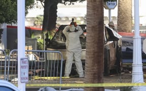 An investigator photographs a Tesla Cybertruck that exploded outside the lobby of President-elect Donald Trump's hotel on January 1, 2025, in Las Vegas. - At least one person was killed and seven wounded when a Tesla Cybertruck exploded outside a hotel belonging to US President-elect Donald Trump in Las Vegas, police said Wednesday. (Photo by WADE VANDERVORT / AFP)
