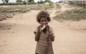 A girl eats a food supplement distributed during a malnutrition screening session organised by the NGO Action Contre la Faim and the World Food Programme (WFP) in the municipality of Ifotaka, in southern Madagascar, on December 14,  2018.