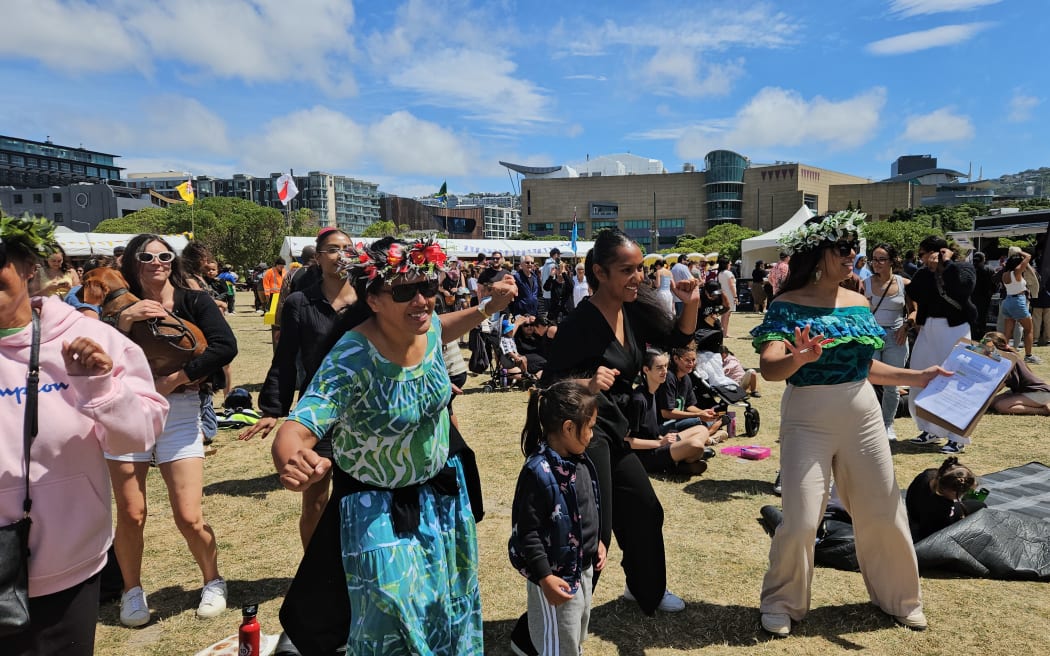 The crowd follows along with traditional Cook Islands dancing.