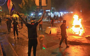 Iraqi protesters burn items to block the road during clashes with security forces following an anti-government demonstration in the Shiite shrine city of Karbala, south of Iraq's capital Baghdad.