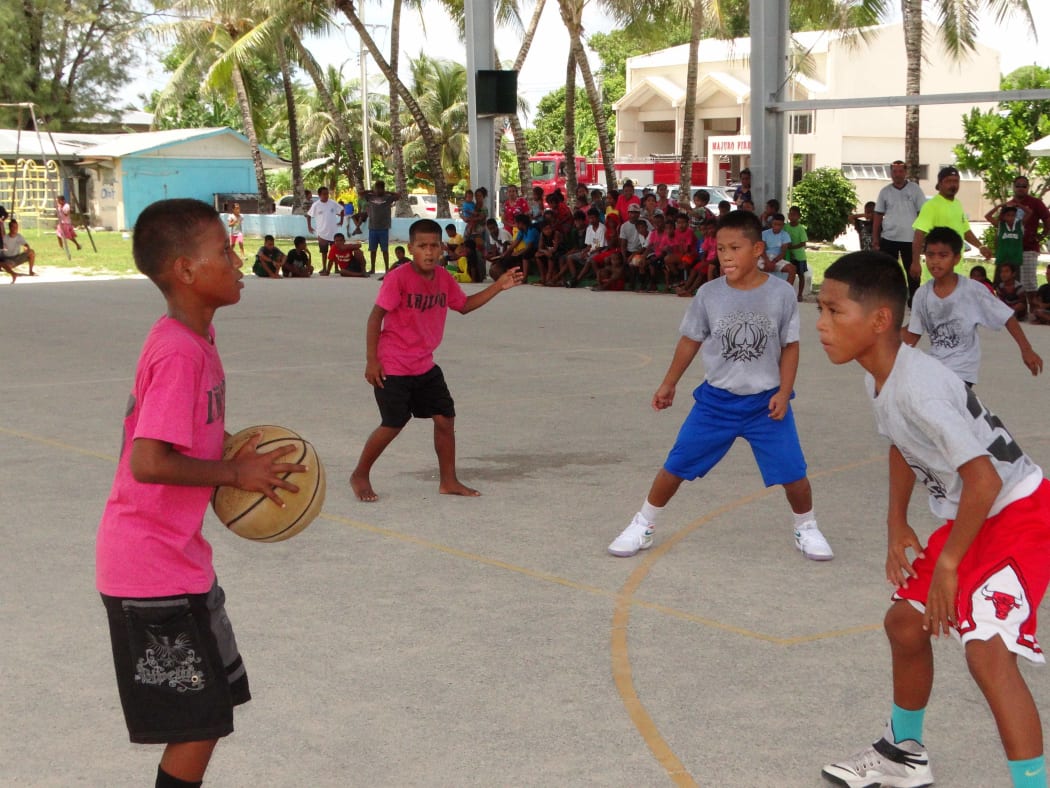 Elementary age students in Majuro competing in a basketball game.