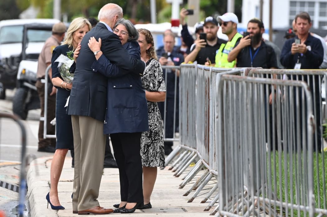 US President Joe Biden (C) hugs Miami-Dade County Mayor Daniella Levine Cava today.