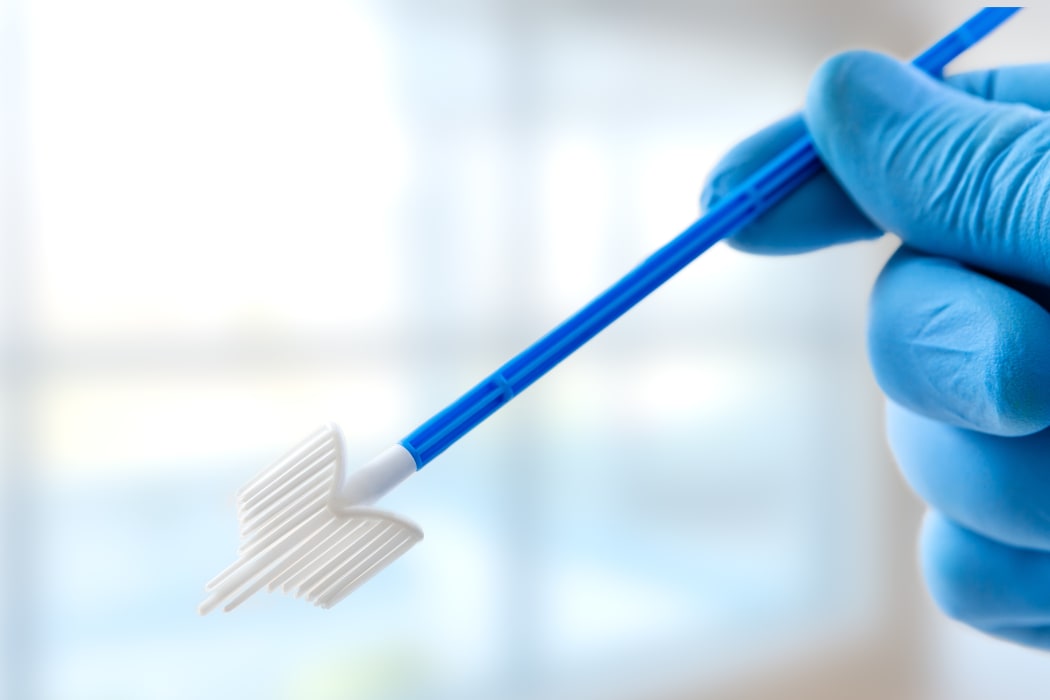 Holding vaginal smear test.