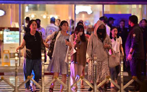 People leave Siam Paragon shopping centre in Bangkok on October 3, 2023, following a shooting incident in the mall.