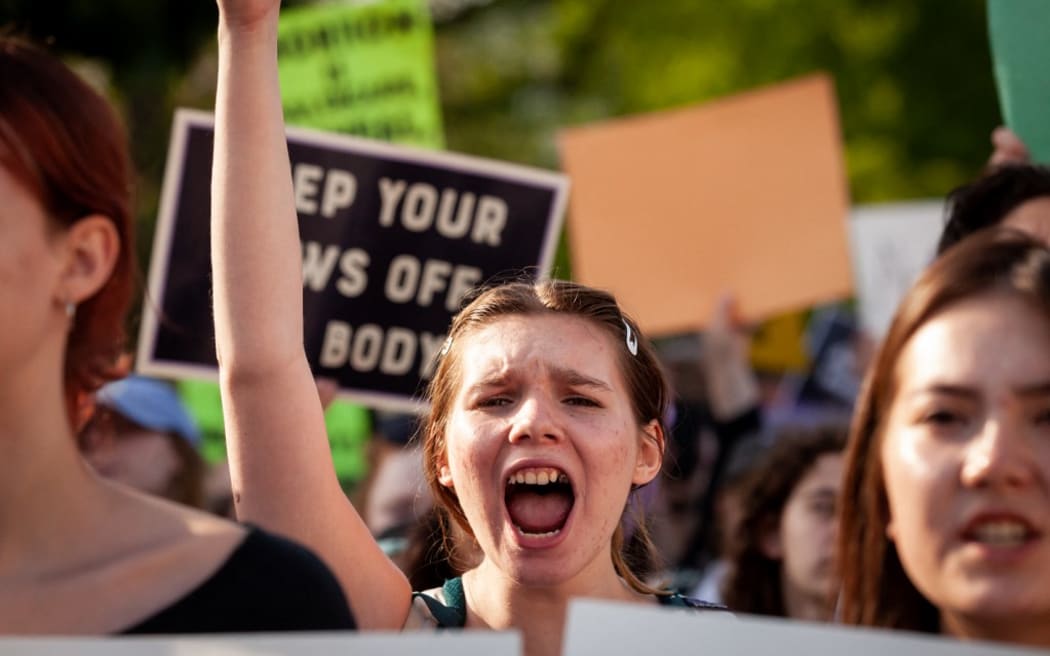 A pro-choice demonstrator cheers during a rally at the Supreme Court the day after learning that Court justices voted to overturn Roe v. Wade in a draft opinion.