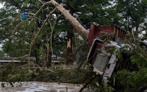 CENTER POINT, TEXAS - JULY 05: A large truck is impaled onto a tree after flash flooding on the bank Guadalupe River on July 5, 2025 in Center Point, Texas. Heavy rainfall caused flooding along the Guadalupe River in central Texas with multiple fatalities reported.   Jim Vondruska/Getty Images/AFP (Photo by Jim Vondruska / GETTY IMAGES NORTH AMERICA / Getty Images via AFP)