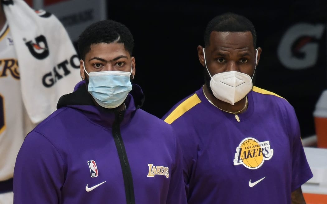 LOS ANGELES, CALIFORNIA - DECEMBER 11: Anthony Davis #3 and LeBron James #23 of the Los Angeles Lakers watch a preseason game against the LA Clippers from the sidelines at Staples Center on December 11, 2020 in Los Angeles, California.