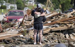 Local residents hug in front of their tornado damaged home, Wednesday, May 22, 2024, in Greenfield, Iowa. (AP Photo/Charlie Neibergall)