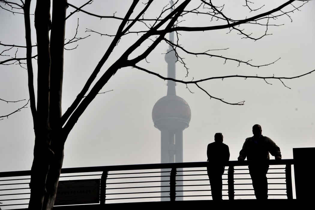 Local residents walk on the Waibaidu Bridge against skyline of the Lujiazui Financial District with the Shanghai Tower in heavy smog in Pudong, Shanghai, China, on 11 March 2019.