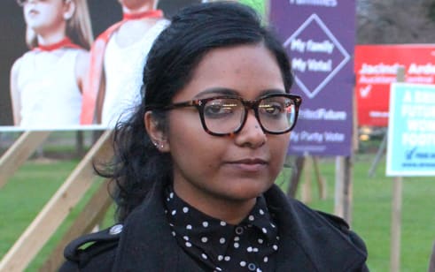 A photo of Saziah Bashir and Fern Seato outside election campaign billboards