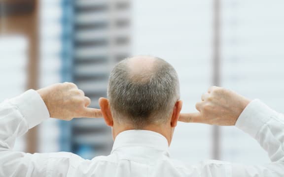 Man putting his fingers in his ears (Photo by Huber & Starke / Image Source / Image Source via AFP)