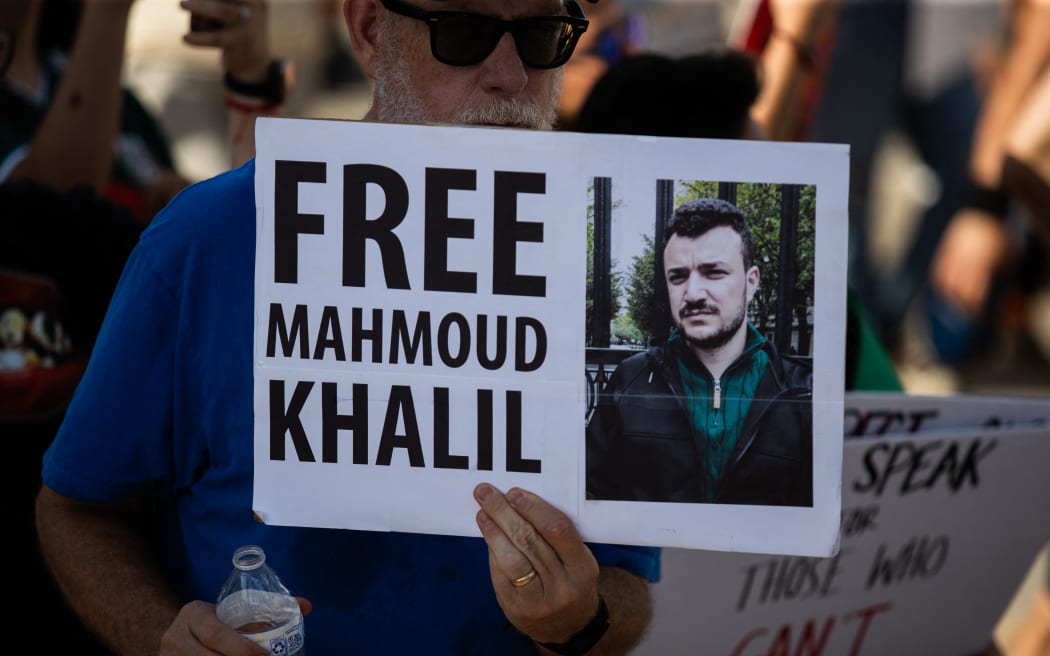 Protesters gather at Ervan Chew Park in Houston, Texas, on June 8, 2025, for a demonstration against Trump's immigration policies and mass deportations. A protester holds a sign that reads, ''Free Mahmoud Khalil.'' (Photo by Reginald Mathalone/NurPhoto) (Photo by Reginald Mathalone / NurPhoto via AFP)
