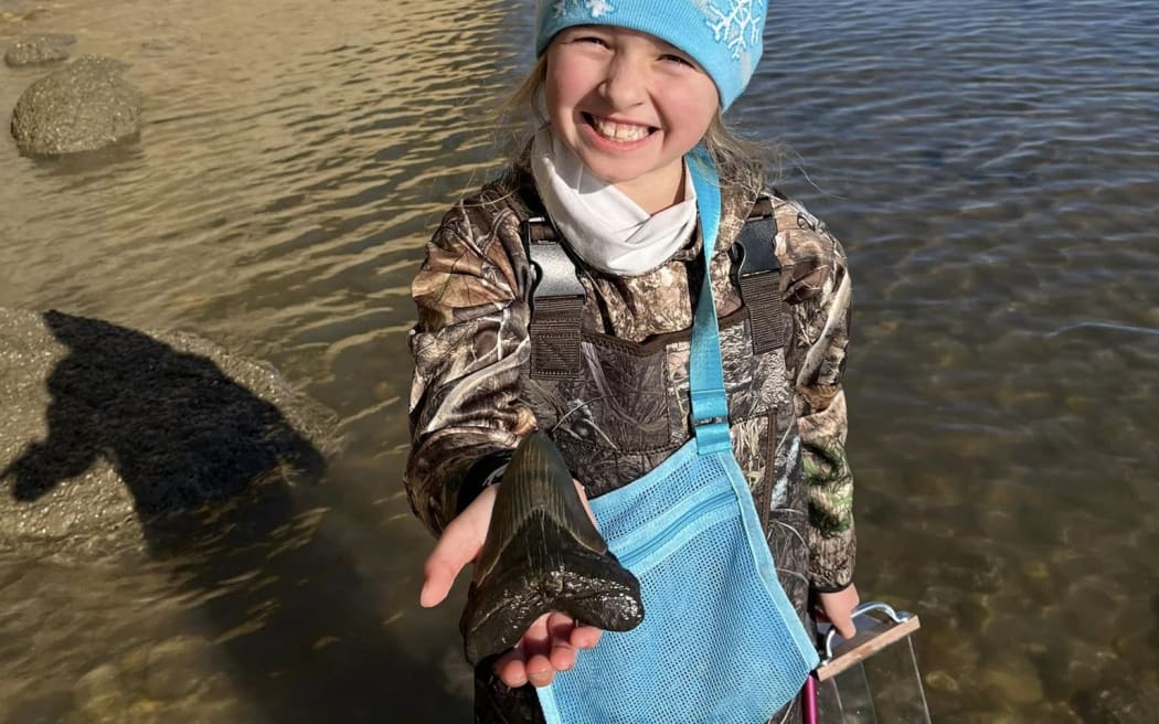 Molly poses with her megalodon tooth.